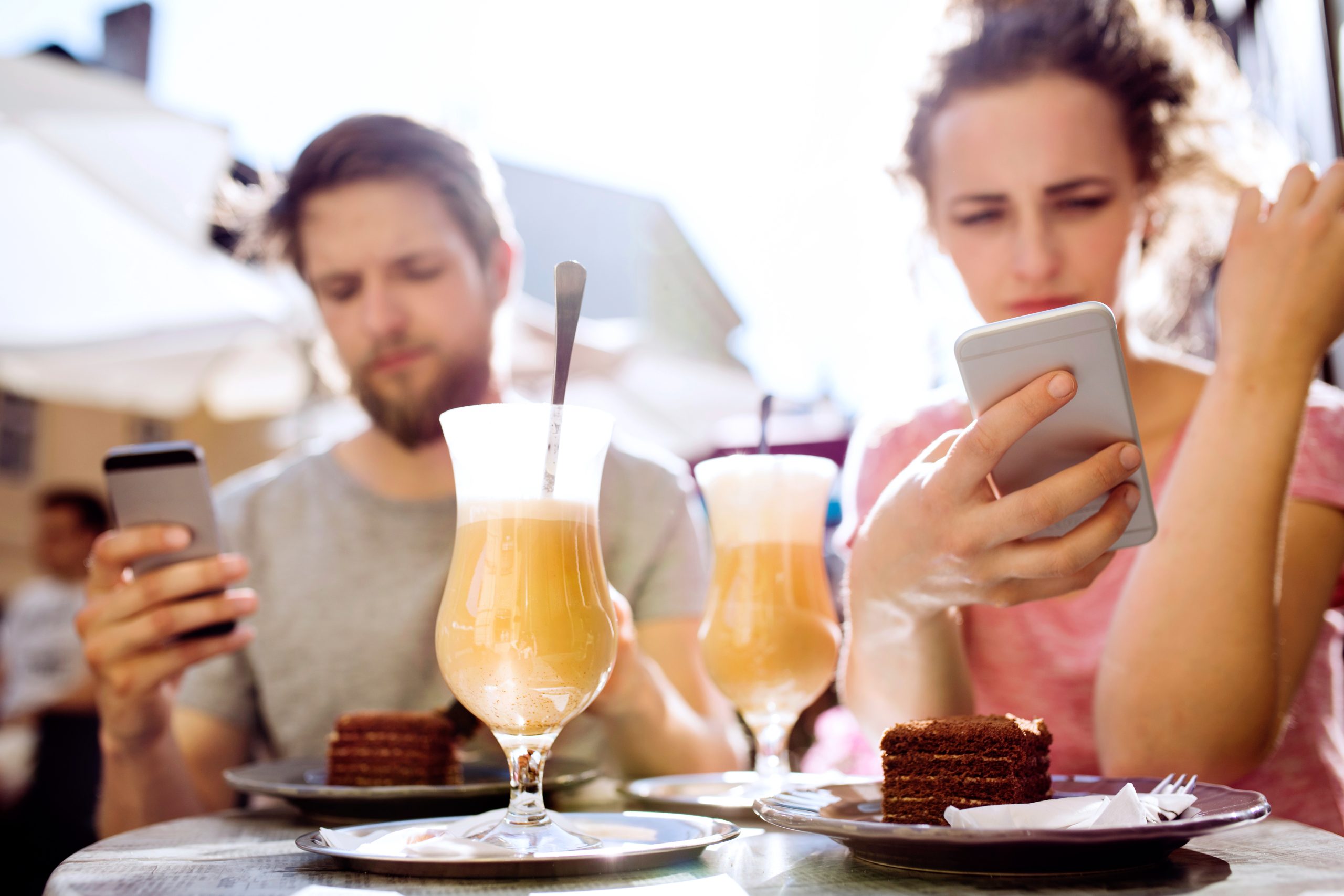 married couple looking at phones in need of marriage counseling